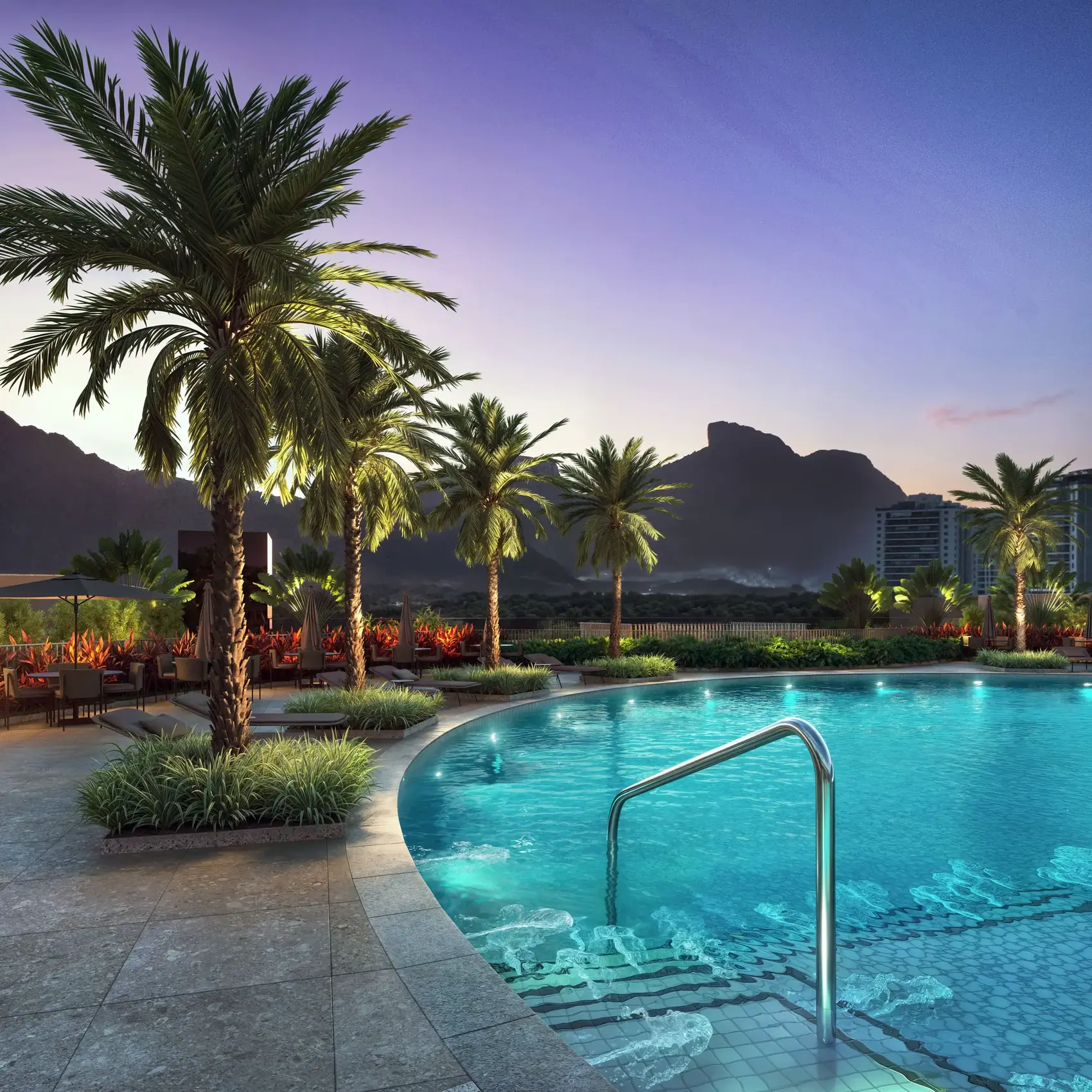Piscina recreativa e solário ao entardecer com a Pedra da Gávea ao fundo